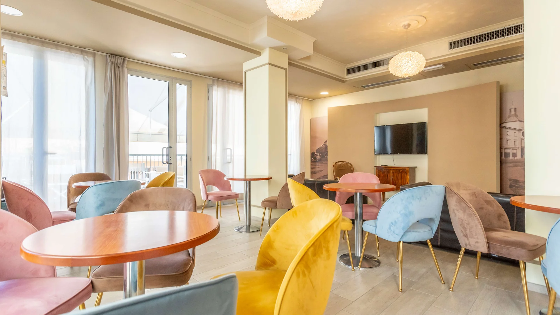 Sala luminosa con tavoli rotondi e sedie colorate in un salotto moderno