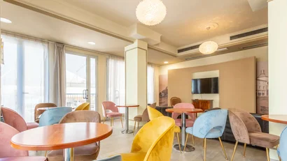 Sala luminosa con tavoli rotondi e sedie colorate in un salotto moderno